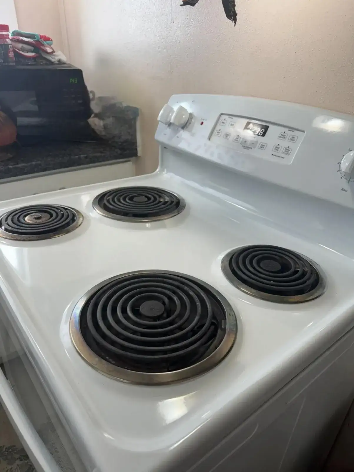 After: the same stove cleaned bright white, burners and knobs spotless