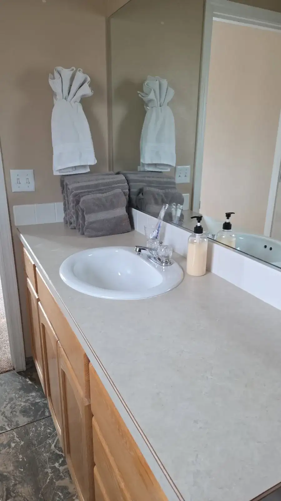 Bathroom counter wiped clean, with folded towels and a clean sink