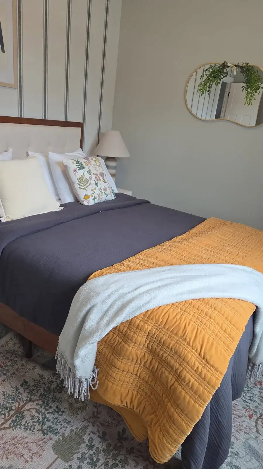 Guest bedroom with a neatly made bed and a folded throw blanket